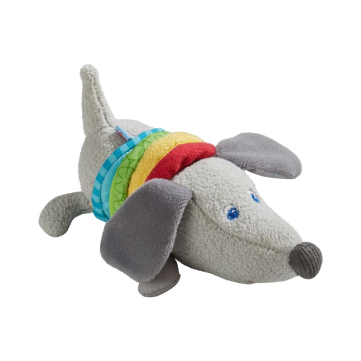 Ein graues Plüsch-Hundespielzeug mit Schlappohren, blauen gestickten Augen und einer runden Nase, mit bunten Stoffringen um den Hals. Das Spielzeug ist aus weichem, strukturiertem Material gefertigt.