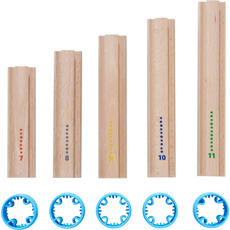 Fünf Holzstäbe unterschiedlicher Länge, die jeweils mit einer farbigen Zahl (7-11) und einem entsprechenden Punktmuster versehen sind, sind aufrecht angeordnet. Darunter befinden sich fünf blaue runde Kunststoffteile mit zahnradähnlichen Zähnen.