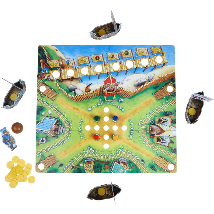 Ein farbenfrohes Brettspiel wird mit runden Spielsteinen, Pappschiffen an jeder Ecke, Goldmünzen und einem braunen Ball aufgebaut. Das Spielbrett hat einen zentralen Bereich mit farbigen Markern und illustrierten Wegen, die zu verschiedenen Zonen führen.