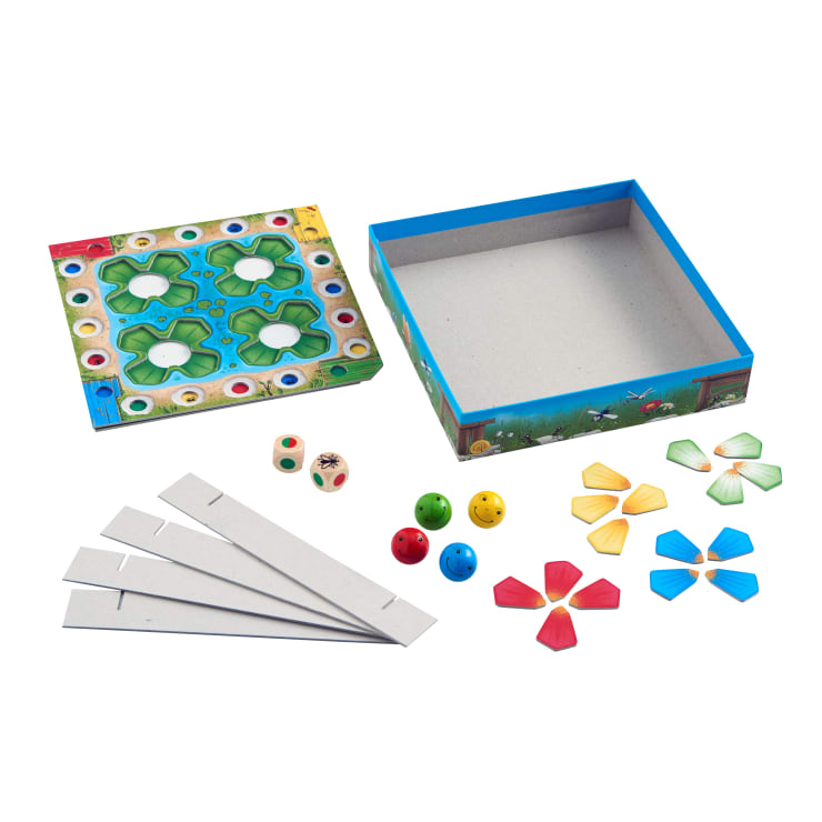 Ein Brettspielset mit einer offenen Schachtel, einem bunten Spielbrett, vier Pappstreifen, zwei Würfeln, vier farbigen Froschfiguren aus Holz, vier blumenförmigen Pappsets und ein paar kleinen blauen Kugeln.