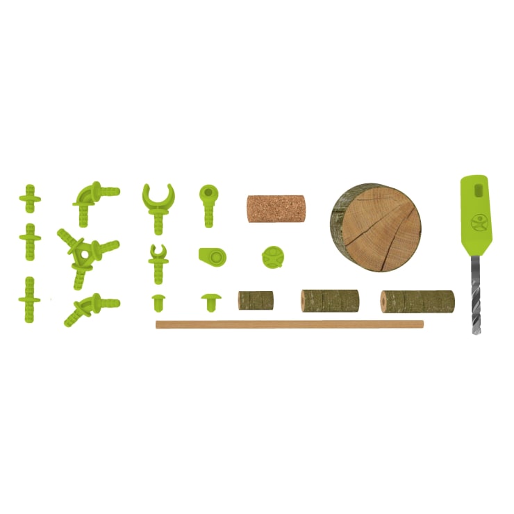 Ein Satz grüner Kunststoffstecker, ein Korkzylinder, eine runde Holzscheibe, mehrere Holzdübel, ein Holzstab und eine Handbohrmaschine mit grünem Griff und Bohrer sind auf einem weißen Hintergrund angeordnet.