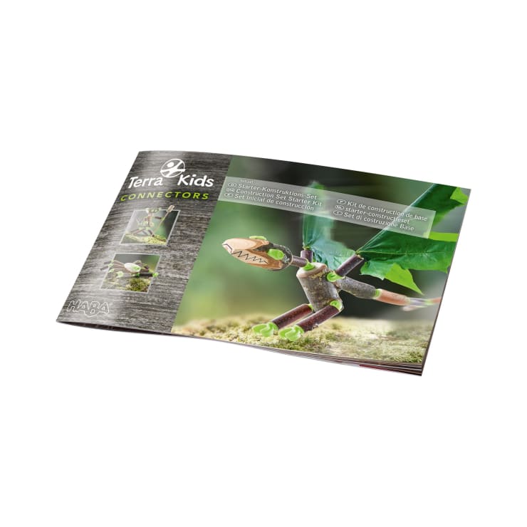 Ein Terra Kids Connectors Booklet, das auf einer Seite aufgeschlagen wird, die Holzstabmodelle zeigt, die mit grünen Plastikteilen verbunden sind, einschließlich Nahaufnahmen der Verbindungsstücke und des Laubes im Hintergrund.