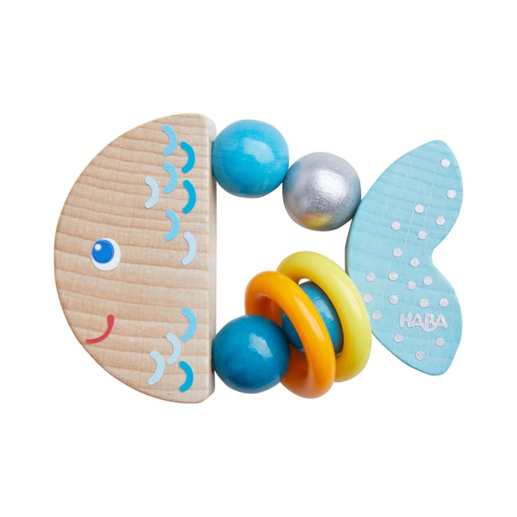 Ein Babyspielzeug aus Holz und Kunststoff in Form eines Fisches, mit einem Kopf aus Naturholz, blau bemalten Perlen, gelben Ringen und einem hellblauen Schwanz mit weißen Punkten und dem Schriftzug HABA.