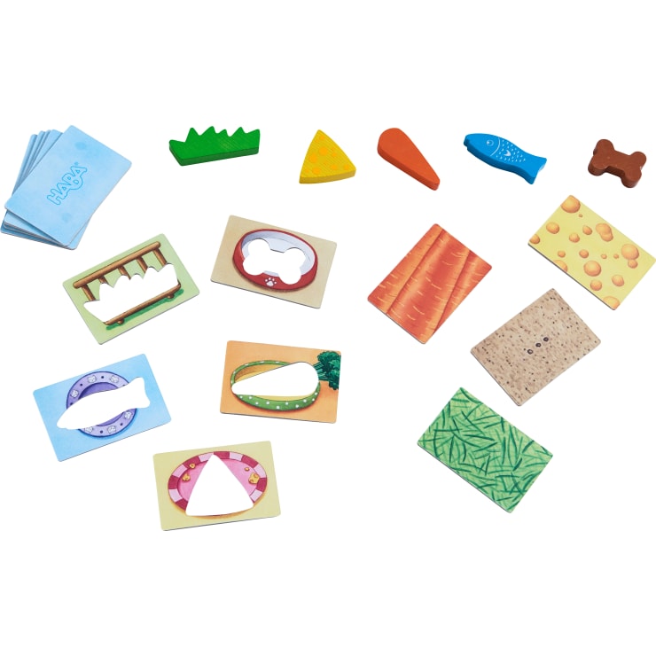 Ein Set mit passenden Spielfiguren, das illustrierte Karten mit ausgeschnittenen Formen wie Fisch, Knochen und Käse sowie entsprechende Spielsteine aus Holz oder Karton in Form von Lebensmitteln und Gegenständen enthält.
