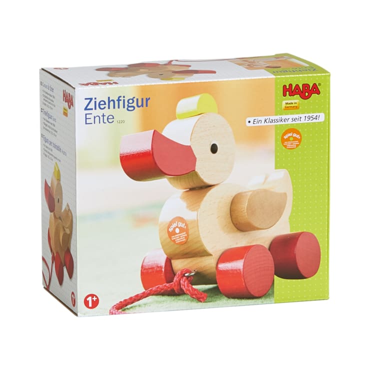 Eine Schachtel mit einer HABA-Nachzieh-Ente aus Holz mit roten Rädern und einer roten Kordel. Die Verpackung ist mit Produktbildern und deutschem Text versehen und gibt an, dass es für Kinder ab 1 Jahr geeignet ist.