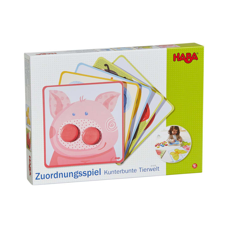 Gezeigt wird eine Schachtel des Zuordnungsspiels Kunterbunte Tierwelt" von HABA. Auf der Vorderseite sind bunte Tierkarten aufgefächert, auf denen ein Schwein abgebildet ist, mit einer Altersempfehlung ab 1,5 Jahren.