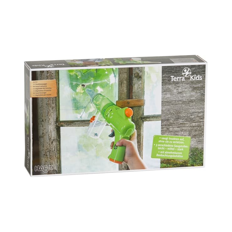 Eine Verpackung für den Terra Kids Insektenstaubsauger von HABA zeigt eine Hand, die ein grünes Plastiksauggerät in Richtung eines Fensters mit Blättern draußen hält. Die Verpackung enthält Produktinformationen in mehreren Sprachen.