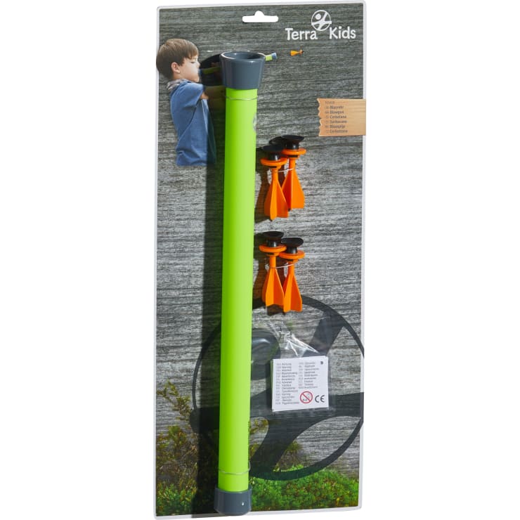 Ein verpacktes Terra Kids Spielzeugset, das ein grünes Blasrohr, vier orangefarbene Schaumstoffpfeile mit schwarzen Spitzen und ein Anleitungsblatt enthält. Auf der Verpackung sind ein Kind, das das Blasrohr benutzt, und das Terra Kids Logo abgebildet.