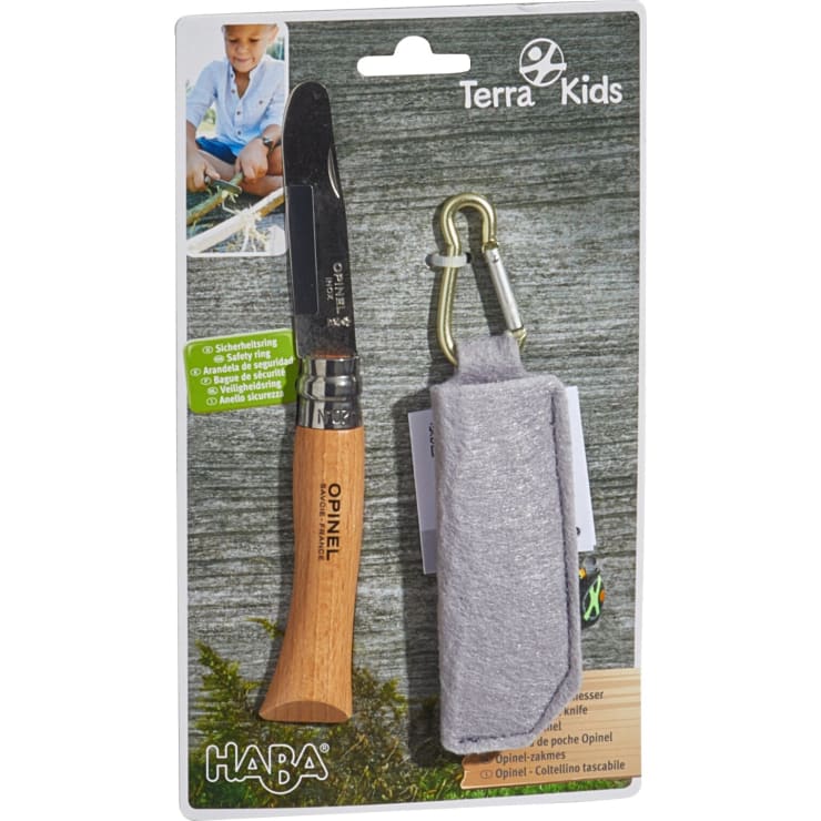 Ein verpacktes Opinel-Taschenmesser mit Holzgriff wird neben einer grauen Stoffscheide mit Metallkarabiner gezeigt. Die Verpackung ist mit der Marke HABA Terra Kids versehen und enthält Sicherheitsinformationen in vier Sprachen.