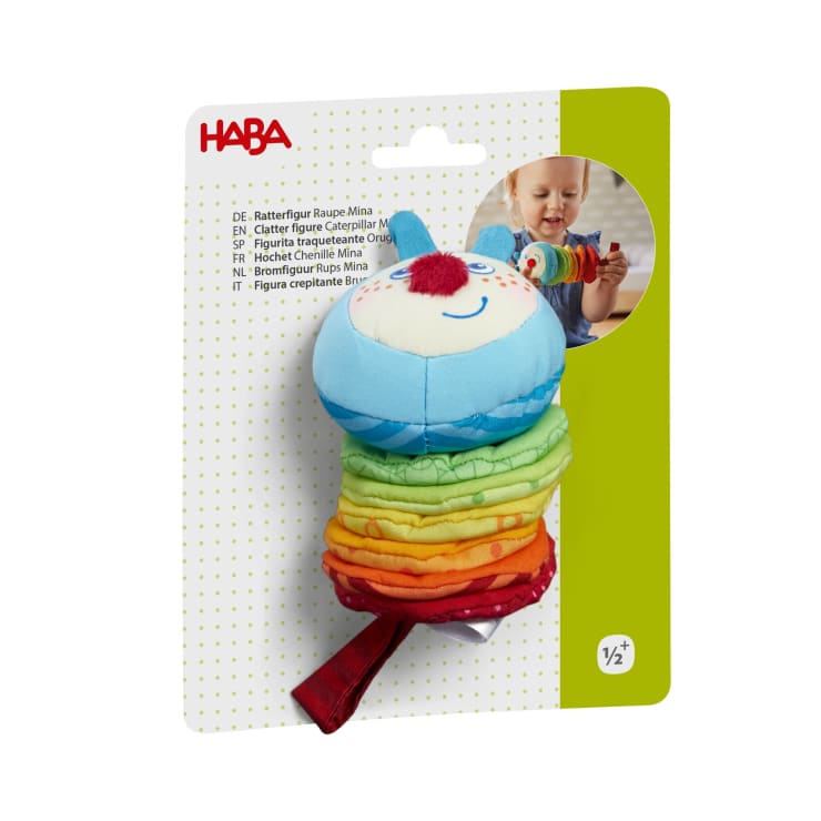 Ein farbenfrohes Plüsch-Babyspielzeug von HABA ist in seiner Verpackung abgebildet und zeigt in der oberen rechten Ecke ein Foto eines Babys, das mit dem Spielzeug spielt. Auf der Verpackung ist angegeben, dass das Spielzeug für Kinder ab 1/2 Jahr geeignet ist.