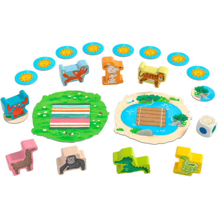 Ein Brettspiel mit tierförmigen Holzfiguren, kreisförmigen Plättchen mit Sonnenmotiven, einer grünen Matte, einer Wasserfläche mit einem Floß, einem Krabbenmotiv und einem weißen Würfel mit farbigen Punkten.