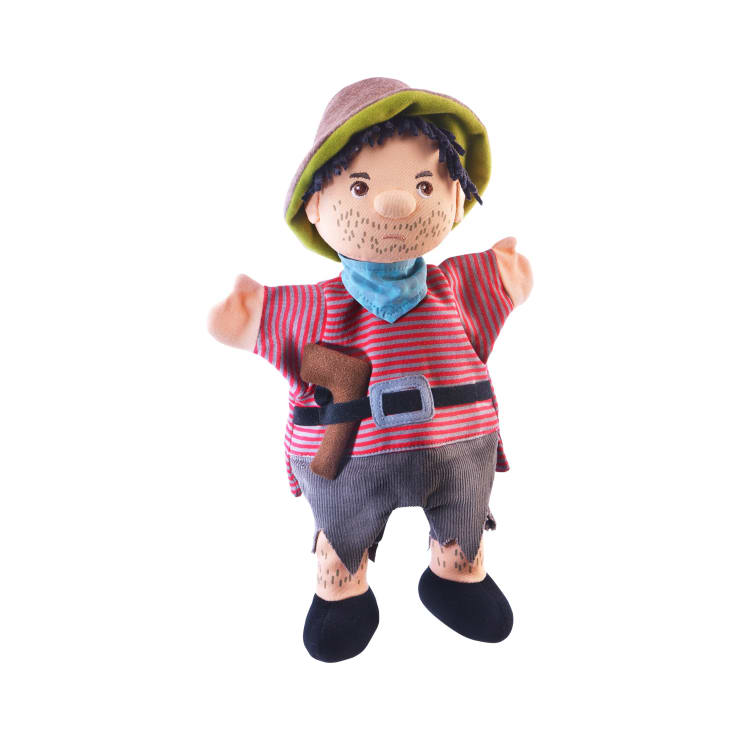 Plüschhandpuppe einer Person, die ein gestreiftes rotes Hemd, graue Shorts und einen braunen Schlapphut trägt, dazu einen blauen Schal und schwarze Schuhe. Die Handpuppe hat aufgemalte Bartstoppeln und eine Stoffaxt, die im Gürtel steckt.