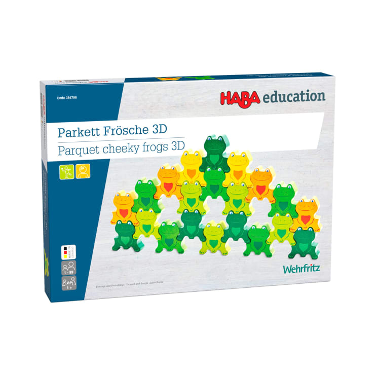 Eine Schachtel mit HABA education Parkett freche Frösche 3D mit einem Bild von bunten froschförmigen Teilen, die in einer Pyramide auf der Vorderseite angeordnet sind. Auf der Schachtel sind außerdem Icons und das Wehrfritz-Logo abgebildet.
