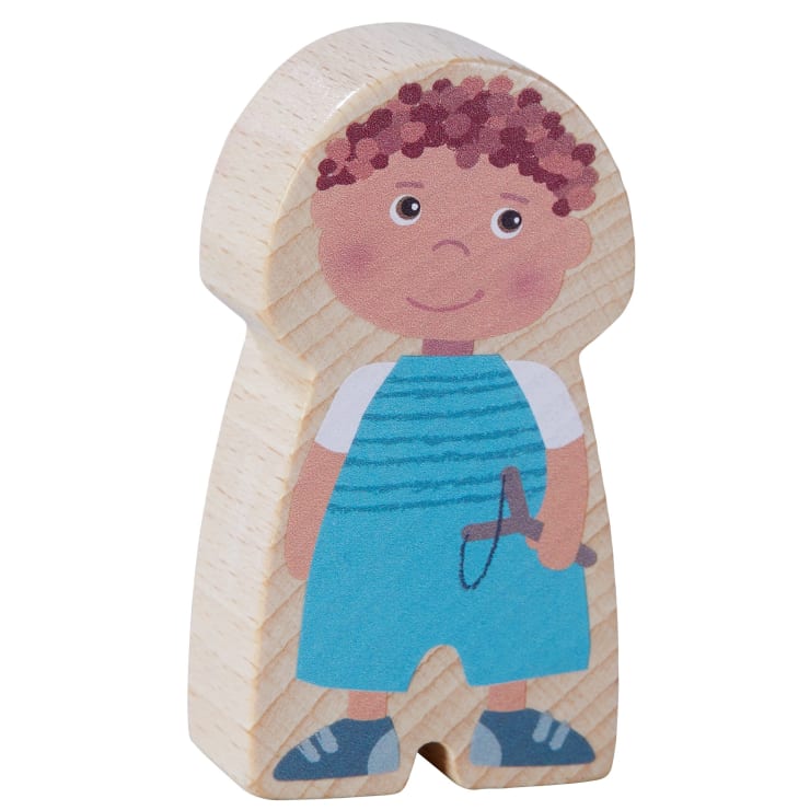 Eine hölzerne Spielzeugfigur mit aufgemalten Merkmalen, darunter braune lockige Haare, ein blau-weiß gestreiftes Hemd, eine blaue Latzhose und blaue Schuhe. Die Figur hat ein einfaches lächelndes Gesicht und hält ein Springseil.