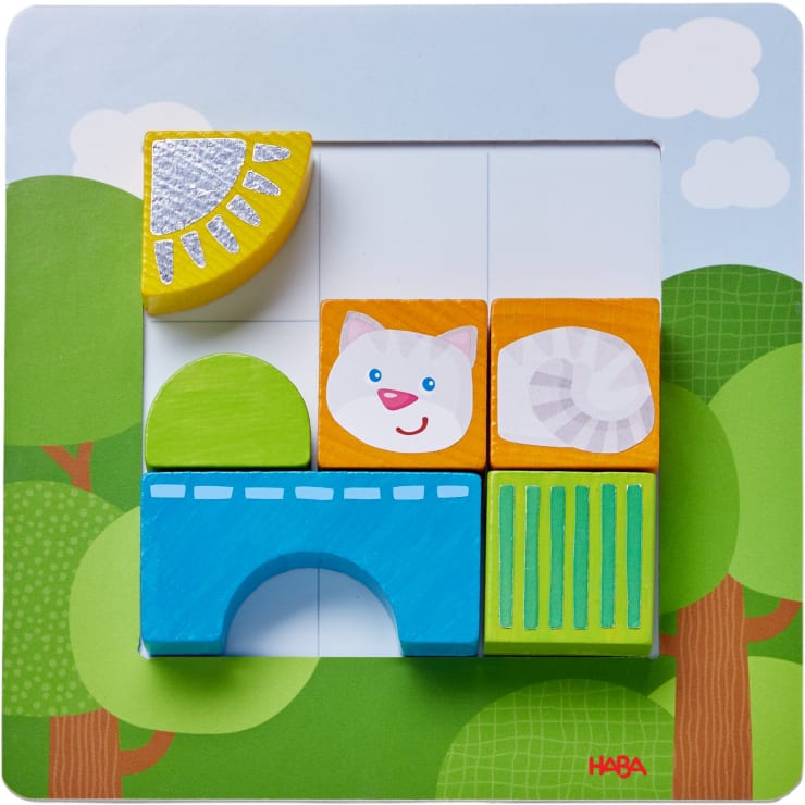 Ein Holzpuzzle mit farbenfrohen Blöcken, darunter eine Sonne, ein grüner Halbkreis, eine blaue Brücke, ein Katzengesicht, eine spiralförmige Muschel und grüne Balken, die alle in einem quadratischen Rahmen mit einem Baum und einem Himmel im Hintergrund liegen.