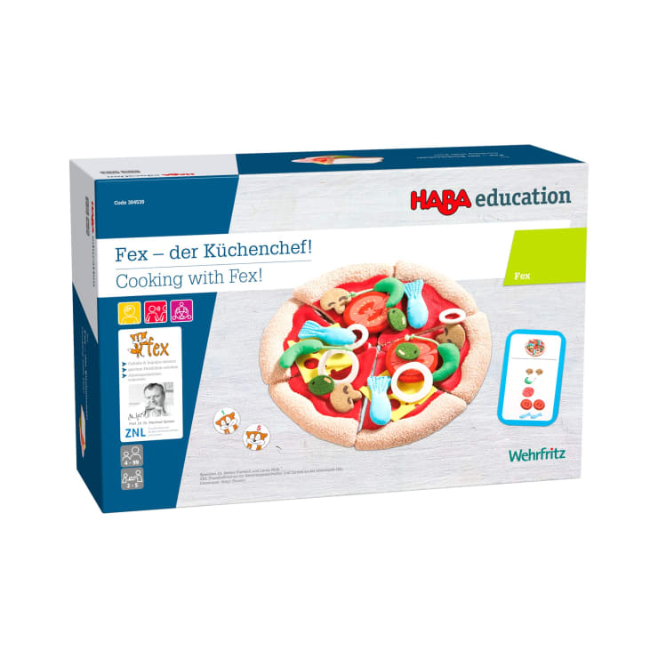 Eine Schachtel mit dem HABA Education Spiel Fex - der Küchenchef! Kocht mit Fex! mit einer illustrierten Spielzeugpizza mit verschiedenen bunten Belägen auf der Vorderseite der Verpackung.
