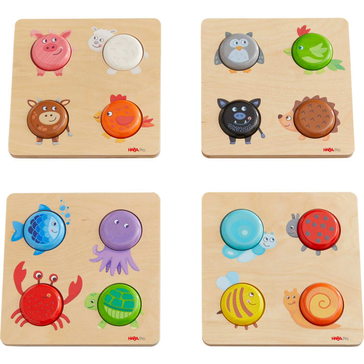 Vier hölzerne Tierpuzzles mit bunten, kreisförmigen Teilen; die Puzzles zeigen Cartoon-Bilder eines Schweins, eines Schafs, einer Eule, eines Vogels, eines Bären, eines Huhns, einer Krabbe, eines Fisches, einer Schildkröte, einer Schnecke und einer Biene auf einem hellen Holzhintergrund.