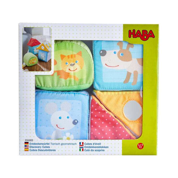 Schachtel mit HABA-Entdeckerwürfeln mit vier bunten, weichen Blöcken mit Tiermotiven, darunter eine Katze und ein Hund. Die Verpackung hat ein Fenster mit den Würfeln und ein kleines Bild, das das Produkt zeigt.