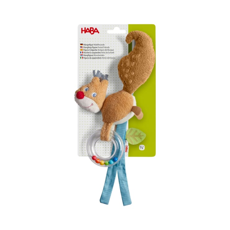 Plüsch-Eichhörnchen mit Ringelschwanz, blauer Schleife und bunten Perlen auf einer Aufhängekarte mit mehrsprachigem Text und HABA-Logo. Geeignet für Kleinkinder ab ½ Jahr und älter.