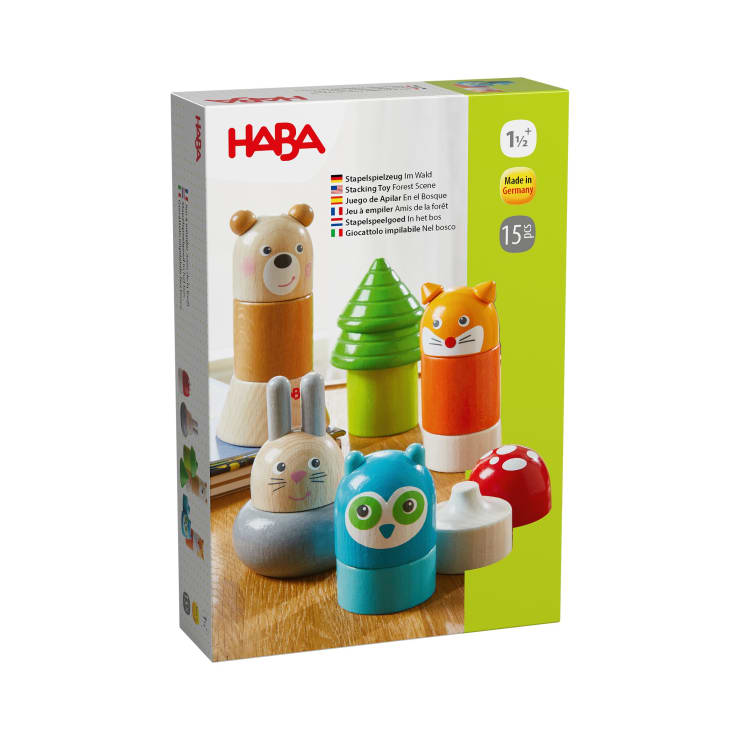 Eine Schachtel mit HABA-Stapelspielzeug aus Holz mit 15 Teilen zum Bauen von Tieren und Objekten wie einer Eule, einem Hasen, einem Fuchs, einem Baum und einem Pilz. Die Verpackung ist hauptsächlich weiß und grün mit bunten Illustrationen.