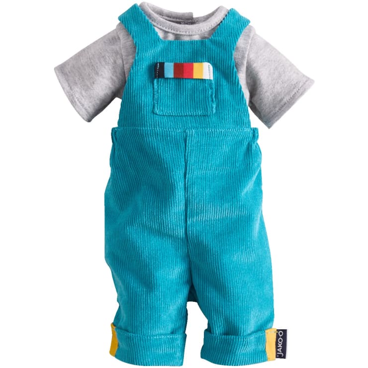 Ein graues, kurzärmeliges T-Shirt wird mit einem türkisblauen Cord-Overall kombiniert, der eine kleine Brusttasche und ein mehrfarbiges Streifendetail aufweist; die unteren Manschetten und die Tasche sind mit gelben und blauen Stoffetiketten versehen.