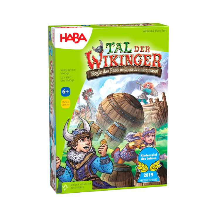Eine farbenfrohe Schachtel für das Brettspiel Tal der Wikinger von HABA, die Cartoon-Wikinger, große Fässer und Schiffe zeigt. Das Spiel ist ab 6 Jahren freigegeben und zeigt auf der Vorderseite verschiedene Preisabzeichen.