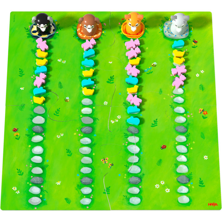 Ein farbenfrohes Spielbrett mit vier Tierfiguren am oberen Rand, die jeweils eine Reihe farblich passender kaninchenförmiger Figuren und Steine entlang grüner, in Bahnen unterteilter Graswege führen.