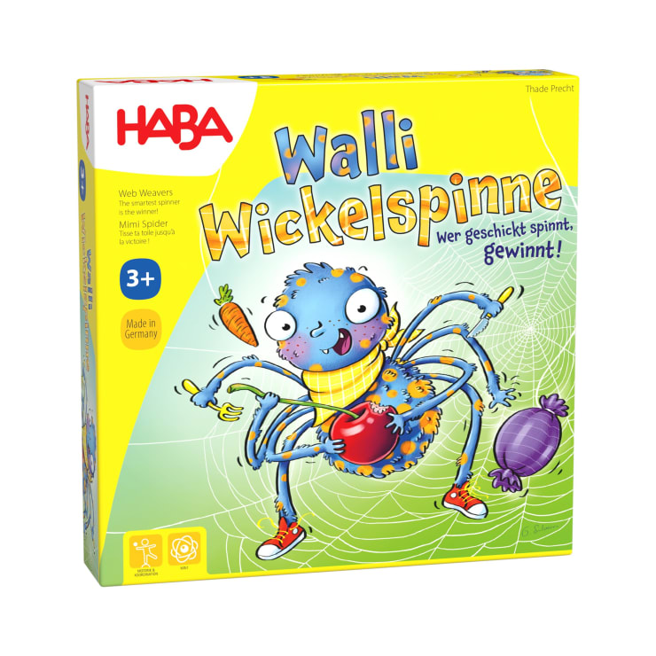 Eine gelbe Schachtel für das Spiel Walli Wickelspinne von HABA. Sie zeigt eine Cartoon-Spinne, die eine Karotte und eine Aubergine hält, mit einem Netz im Hintergrund. Auf der Schachtel steht, dass das Spiel für Kinder ab 3 Jahren geeignet ist.