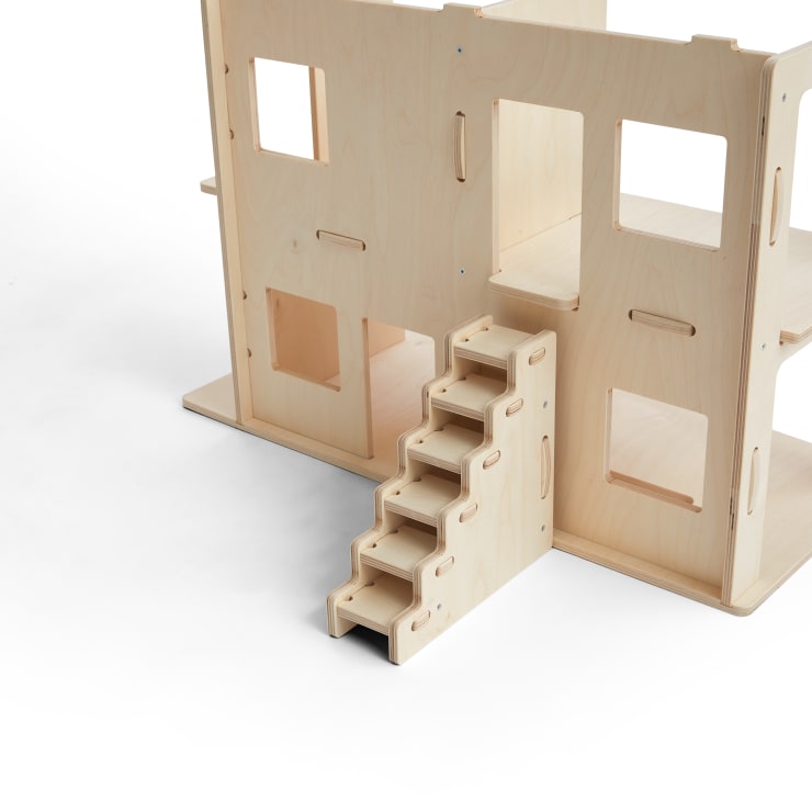 Ein Puppenhaus aus Holz mit mehreren offenen Fenstern und rechteckigen Ausschnitten, mit einer abnehmbaren Treppe, die in den zweiten Stock führt, alles vor einem schlichten weißen Hintergrund.