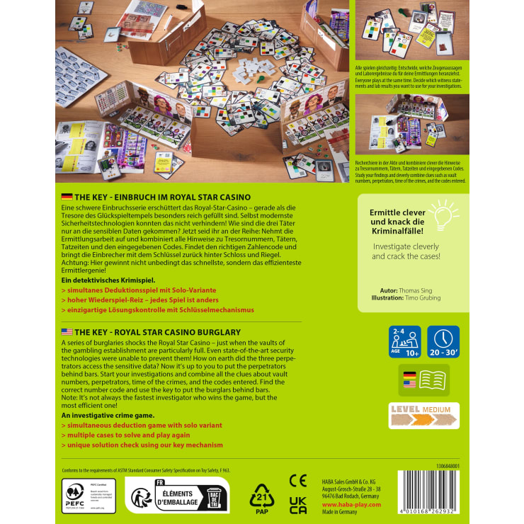 Auf einem Holztisch liegt ein farbenfrohes Brettspiel mit Karten, Spielsteinen, Hinweisblöcken und einer verschlossenen Holzkiste. Die Spielschachtel und das Regelbuch sind ebenfalls zu sehen, und die Spielkomponenten sind übersichtlich verteilt.