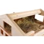 Eine Nahaufnahme eines mit trockenem Heu gefüllten Holzstalls. Der Stall ist oben offen und gibt den Blick auf die Stroheinstreu im Inneren frei. Das Holz hat eine helle Farbe und die Struktur wirkt neu und sauber.