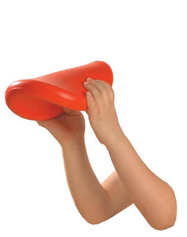 Die Hände eines Kindes halten und drücken ein weiches, flexibles, leuchtend orangefarbenes Objekt vor einem weißen Hintergrund.