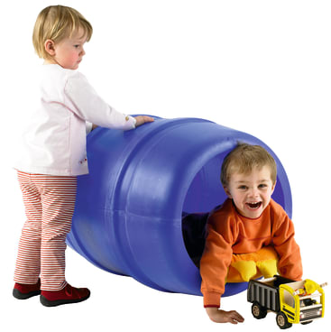 Ein Kleinkind steht neben einem großen blauen Plastiktunnel, während ein anderes Kind lächelnd aus dem Tunnel krabbelt, mit einem gelben Spielzeug-Kipplaster vor sich.