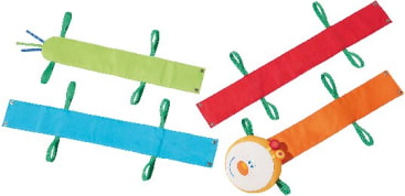 Vier bunte Stoffstreifen mit Schlaufen liegen auf einer weißen Fläche. Die Streifen sind grün, rot, blau und orange, wobei der orangefarbene Streifen an einem Ende eine runde, verzierte Stoffscheibe aufweist.