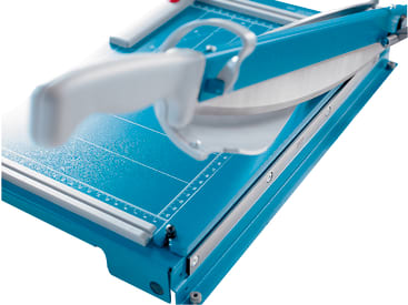 Nahaufnahme einer blauen Papierschneidemaschine mit weißem Griff und Metallklinge, die Messmarkierungen auf der Schneidefläche zeigt.