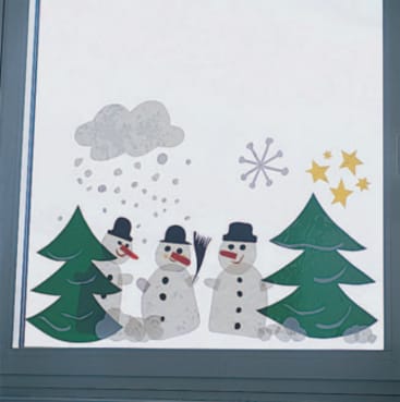 Ein Fenster, das mit Papierausschnitten von drei Schneemännern, zwei immergrünen Bäumen, fallendem Schnee, einer Schneeflocke, einer grauen Wolke und drei gelben Sternen verziert ist.