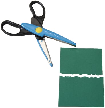 Eine dekorative Kantenschere mit blau-schwarzem Griff liegt neben einem Stück grünem Papier, das so geschnitten wurde, dass es einen gewellten, gemusterten Rand aufweist.