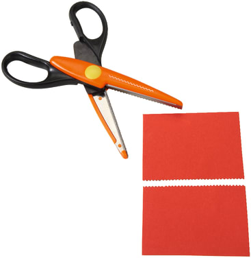 Eine orange-schwarze Zickzack-Schere liegt über zwei roten, rechteckigen Papierstücken mit rosafarbenen Rändern und zeigt ein dekoratives Schnittmuster entlang einer Seite jedes Stücks.