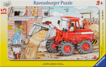 Auf einer Rätselschachtel ist ein roter Frontlader abgebildet, der auf einer Baustelle Sand ablädt. Ein Arbeiter steht in der Nähe, und im Hintergrund ist ein im Bau befindliches Gebäude mit Kränen zu sehen.