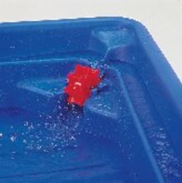 Ein rotes Spielzeugrad schwimmt im Wasser in der Nähe der Ecke eines blauen Plastikbehälters.