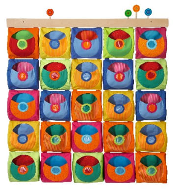 Ein an der Wand montierter Organizer mit fünf Reihen von bunten Stofftaschen, jede mit einem kreisförmigen Muster auf der Vorderseite, die oben an einer Holzleiste mit drei runden Knöpfen befestigt sind.