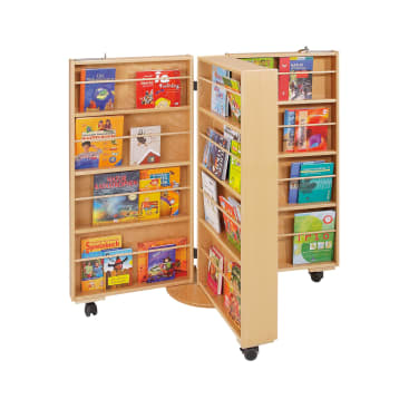 Ein hölzerner, doppelseitiger, drehbarer Bücherständer auf Rädern bietet Platz für verschiedene bunte Kinderbücher, die ordentlich auf mehreren Regalböden angeordnet sind.