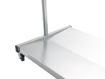 Nahaufnahme der Ecke einer Metallplattform mit einer vertikalen Stange und einem kleinen Rad darunter, wahrscheinlich Teil eines Rollwagens oder Regals.