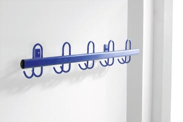 Ein an der Wand montierter blauer Metallkleiderständer mit vier Doppelhaken, der an einer weißen Wand in der Nähe eines Türrahmens angebracht ist.