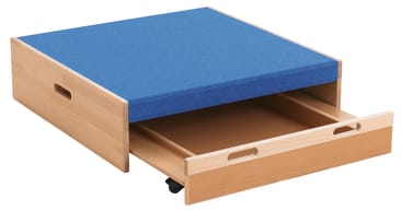 Eine Aufbewahrungsbox aus hellem Holz mit blauem, gepolstertem Deckel, zwei seitlichen Griffen und einer ausziehbaren, teilweise geöffneten Schublade; die Box steht auf kleinen schwarzen Rädern.