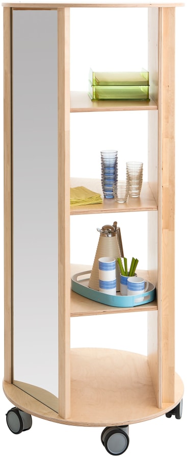 Ein mobiles Regal aus hellem Holz mit einer verspiegelten Seite und drei Einlegeböden, auf denen bunte Tabletts, Gläser und eine Karaffe stehen, alles auf großen schwarzen Rollen.