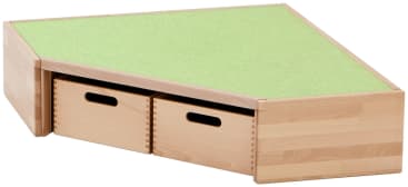 Ein dreieckiges Aufbewahrungsmöbel aus hellem Holz mit grünem Filzbezug und zwei ausziehbaren Schubladen mit ausgeschnittenen Griffen, das in eine Ecke passt.