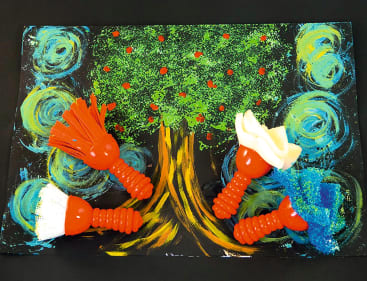 Ein buntes Gemälde eines Baumes mit gelbem und braunem Stamm, grünen Blättern und roten Punkten als Früchte. Vier strukturierte Pinsel mit roten Griffen und unterschiedlichen Pinselköpfen sind auf dem Kunstwerk platziert.
