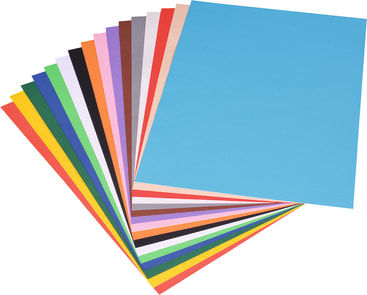 Ein aufgefächerter Stapel farbiger Papierblätter, darunter rot, orange, gelb, grün, blau, lila, schwarz, weiß und andere Farben, wobei das oberste Blatt hellblau ist.