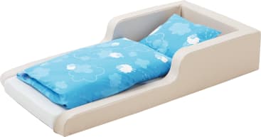 Ein kleines weißes Kinderbett mit hochgezogenen Seitenwänden, mit einer blauen Bettdecke und einem Kissenset mit weißen Schaf- und Wolkenmustern.